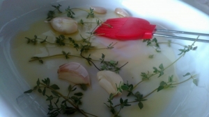 Форму для выпекания смазываем оливковым маслом, выкладываем раздавленный плоской стороной ножа чеснок и веточки свежего тимьяна.