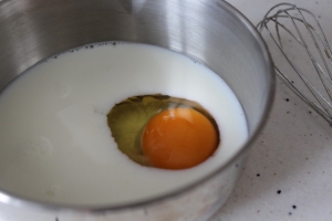 Теперь беремся за крем Шарлотт. Сначала готовим сироп. В кастрюльке смешиваем молоко и яйцо.