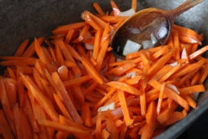 Добавляем к луку морковь, обволакиваем и ее в масле, готовим минут 5. 