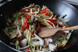 Сковороду-вок хорошо нагреваем и добавляем немного растительного масла, дав ему растечься. Кладем овощи и они начинают журчать в сковороде.