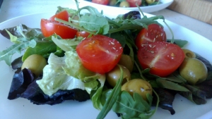 Добавляем нарезанные пополам помидоры, целые оливки и посыпаем итальянскими травками.
