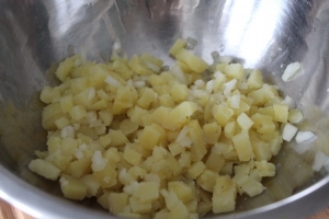 Смешиваем с нарезанным также небольшим кубиком картофелем, солим по вкусу и добавляем сахар.