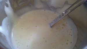 Несколько ложек теста откладываем в тёплое молоко с маслом и перемешиваем.