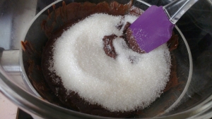 Как только масло и шоколад растворятся, добавляем сахар и легонько перемешиваем. Держим на водяной бане до растворения сахара. Если спешите, сахар можно заменить сахарной пудрой, взяв половину нужного количества.