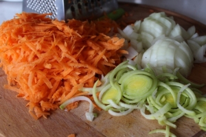 Луковицу режем кубиками, морковь трем на терке, порей нарезаем кольцами.