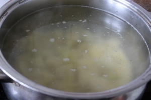Когда вода в кастрюле закипит, солим ее,  добавляем нарезанный крупным кубиком картофель. Убавляем огонь и варим до полуготовности картофеля.